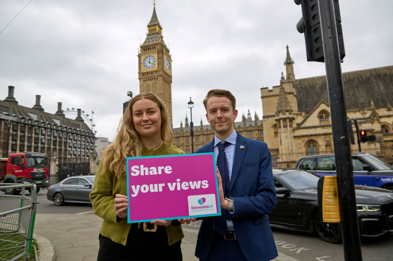 Dementia UK staff holding a 'share your views' sign